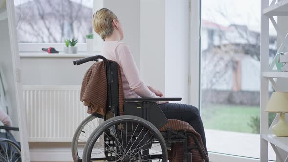 Side View of Joyful Disabled Woman in Wheelchair at Home Waving To Neighbors alt