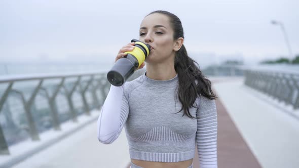 Woman walking and drinking water