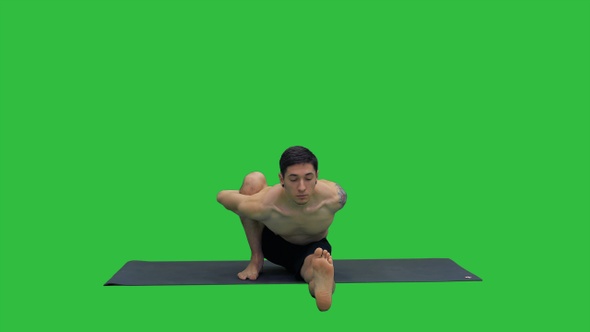 Man in Seated Marichyasana yoga pose stretching leg and alt