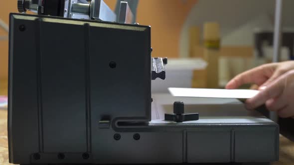 Faceless Worker Using Binding Machine in Printing Office