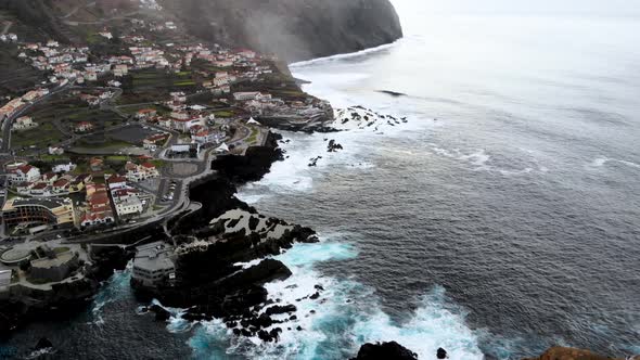 Drone Circle Around Ilheu Mole Cliff Unveiling Porto Moniz Town, Madeira Island, Portugal