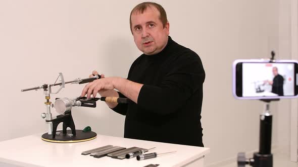 Man Shows a Master Class on Sharpening a Knife on a Machine