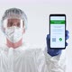 Doctor in Protective Suit Showing a Certificate of Vaccination on a Mobile Phone. - VideoHive Item for Sale