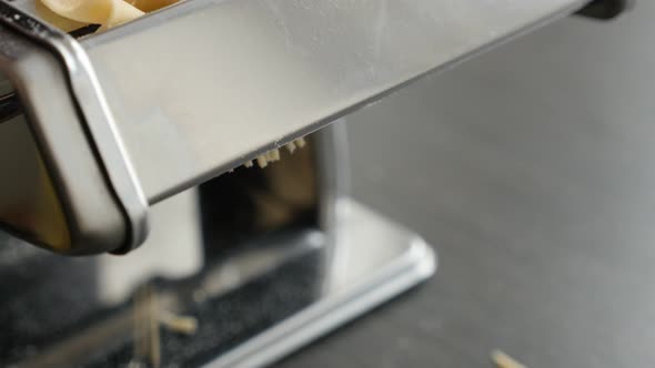 Chrome pasta machine processed Italian spaghetti 4K 2160p 30fps UltraHD footage - Dough made  cylind alt