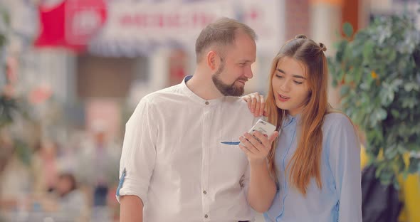 Couple in Mall Selects Item in Phone App alt