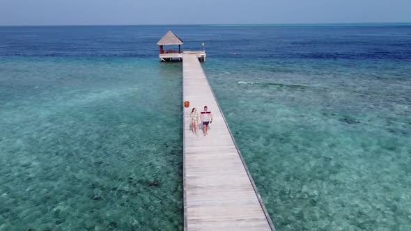 A Man and a Woman Couple Walking on Wooden Decking Bridge Holding Hands