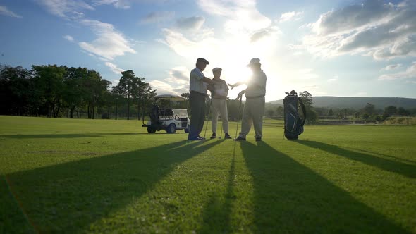 4K Group of Asian men golfer shaking hand after finish the game on golf course at summer sunset alt