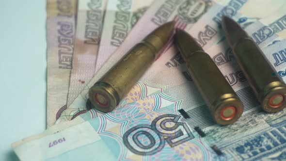 Russian Ruble Money Banknotes and Machine Gun Rifle Bullets Close Up alt
