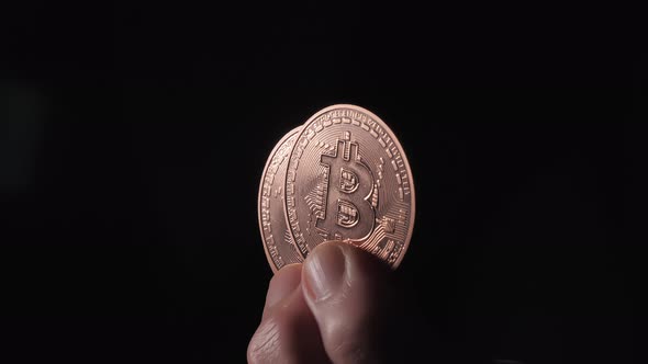 Bitcoin Coins Between the Ladys Fingers