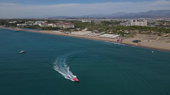 Parasailing Pulled By Speedboat Leaves the Beach alt