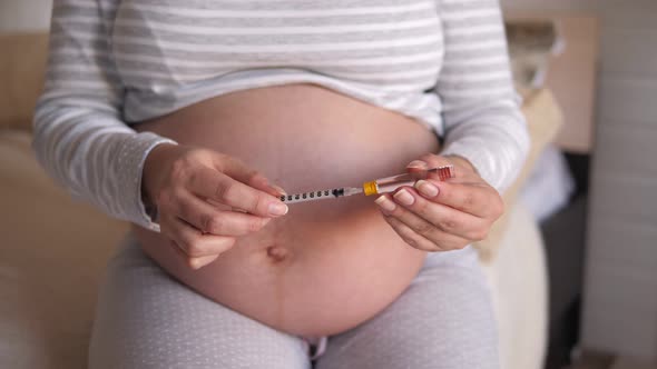 Pregnant Woman Makes Injection of Insulin in Her Belly. Diabetes and Pregnancy. alt