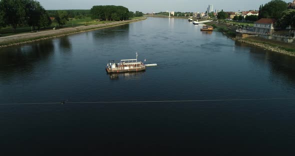Aerial view of a passenger ferry boat crossing Drava river, Osijek, Croatia. alt
