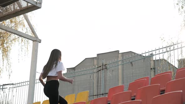 Young Runner in Sportswear Running Up and Down the Ladder of Tribune at Stadium alt