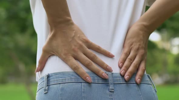 Female Feels Acute Back Pain While Walking Outdoors, Inflammation of Kidneys alt