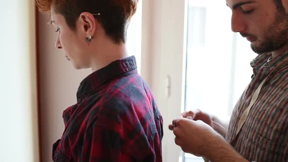 Young designer working garment on model alt