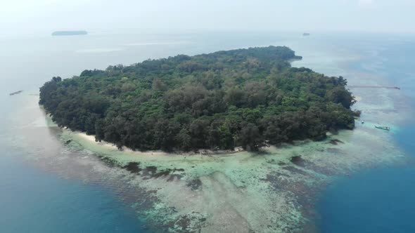 Cinematic aerial view of island in the beautiful blue ocean.