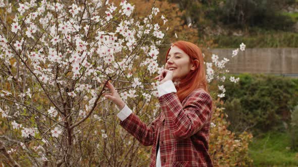 Happy Redhaired Girl Under Spring Flower Tree alt