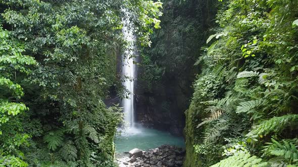 Drone Flying in a Green Lush Tropical Rainforest with Majestic Waterfall in Southeast Asia