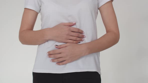 Closeup of a Woman's Belly on Which a Woman Puts Her Hands and Squeezes It alt