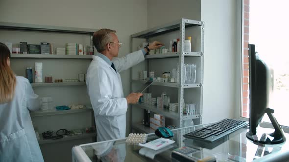 Two Colleagues Pharmacists Checking Up Medicine Stuff in Drug Store alt