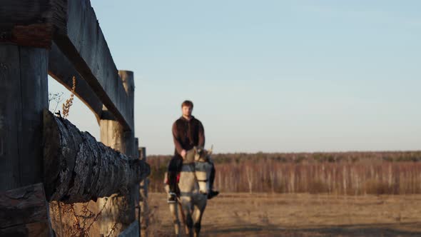 An Adult Man Rides Along a Fence alt