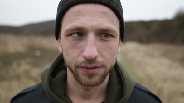 Portrait Of Funny Young Guy. He Runs One Eye To The Side And Laughs. alt