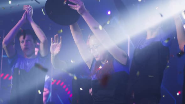 Female Gamer Raising Trophy Near Teammates alt