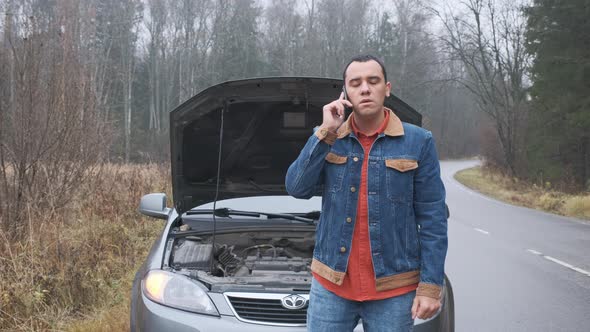 Man Calling Car Assistance Services Because His Car Is Broken