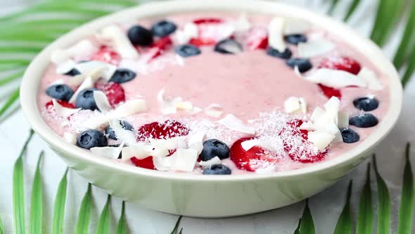 Berry smoothie bowl with strawberries, blueberries and coconut.  alt