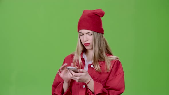 Girl Looks at the Pictures in the Phone and Shows a Thumbs Up. Green Screen. Slow Motion alt