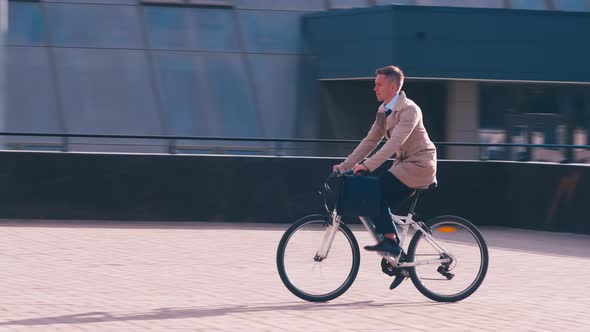 Man in coat riding a bike