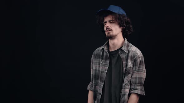 The Young Curly Hipster with the Blue Cap Was Sad and Upset He Wants to Cry but His Pride Doesn't alt