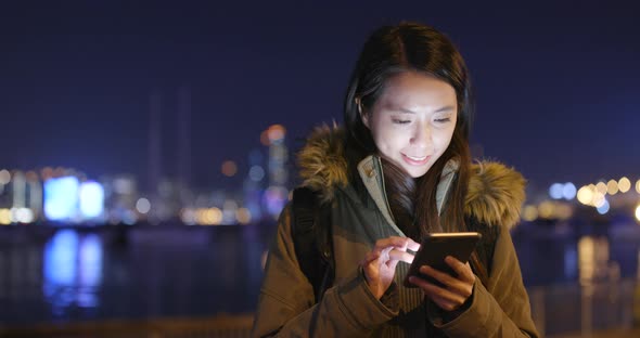 Woman using smart phone at night alt