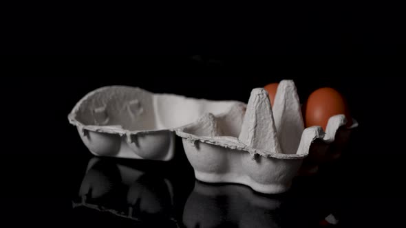 Sliding shot of someone putting in brown eggs in a egg box. alt