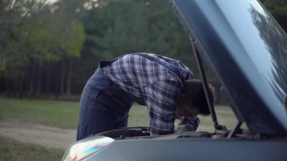 Mechanic in Working Uniform Open Hood Motor Fixing Broken Car on Forest Road