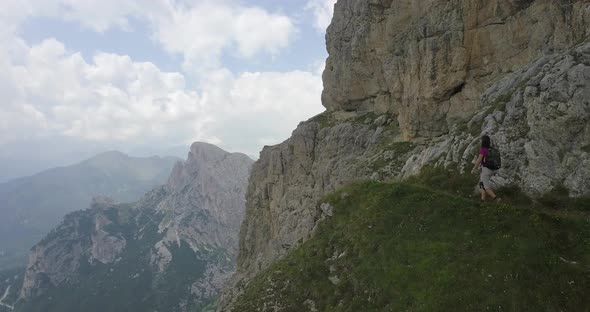 Aerial drone view of a woman hiking in the mountains. alt