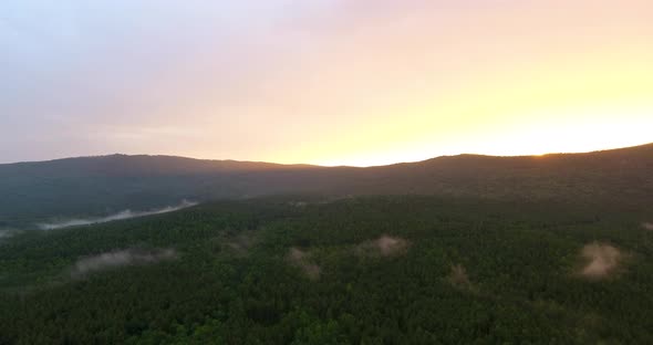 Sun lays down behind the forestal area mountain