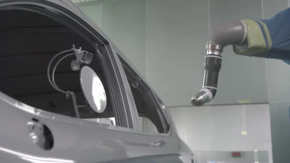 Robotic Arms Spray Painting a Vehicle Body at a Car Manufacturing Factory