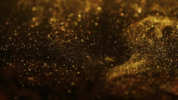 Golden glitter background in slow motion. Gold particles on black background