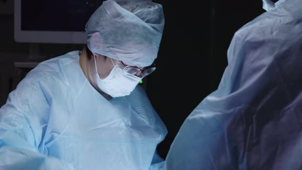 Female surgeon using scissors on operation