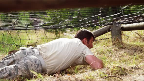 Military soldier crawling under the net during obstacle course 4k alt