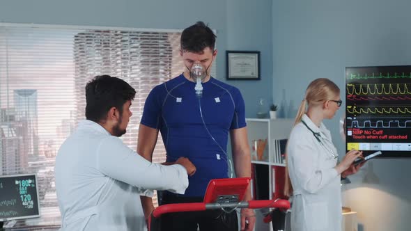 Doctor Preparing Sportsman in Oxygen Mask for Cardio Respiratory Test alt