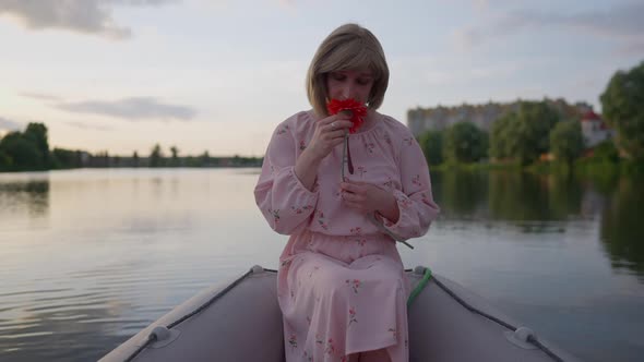 Romantic Trans Woman Smelling Red Flower Sitting in Boat Dreaming alt