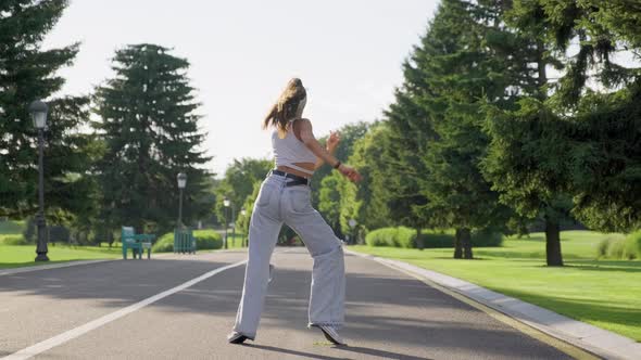 Dancing Young Female Teenager on Road in Park alt