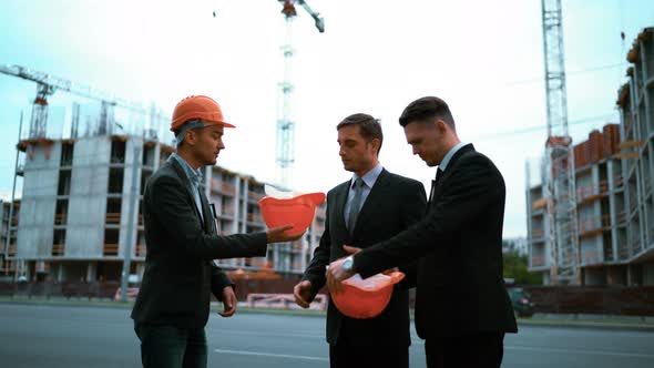 Engineer Giving Businessmen Helmets alt