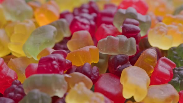 Full Frame Looped Spinning Background of Colorful Jelly Bear Candies Heap alt