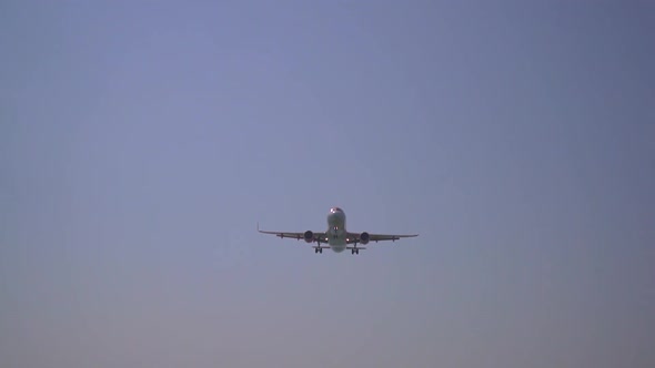 an aircraft is approaching the landing strip and flies over the camera very closely. alt