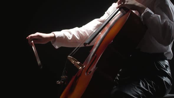Woman Virtuoso Musician Playing Classical Melody on Strings Cello in Studio Black Background Side alt