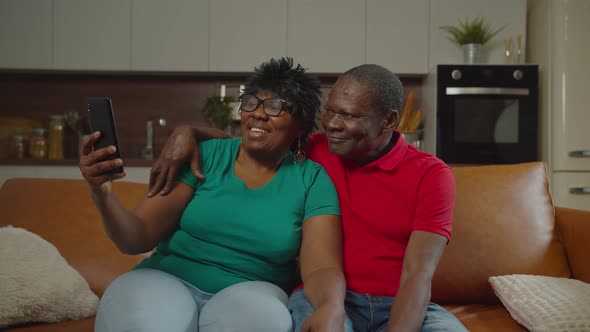 Happy Senior Couple Taking Selfie on Phone at Home alt
