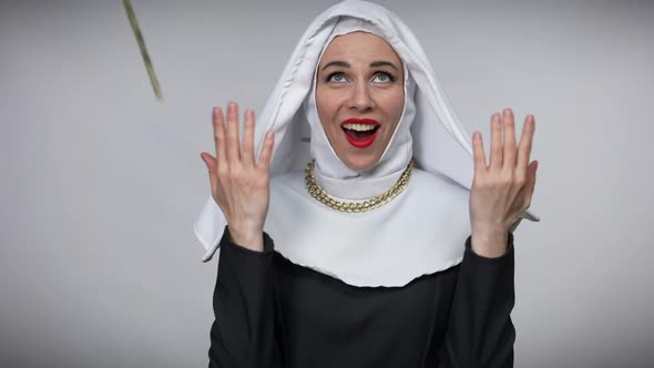 Portrait of Praying Woman in Nun Costume Posing with Excited Facial Expression As Money Falling in alt